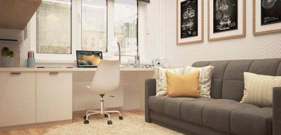 Chambre d'étudaint avec un bureau, un canapé, un tapis au sol et des cadres au mur