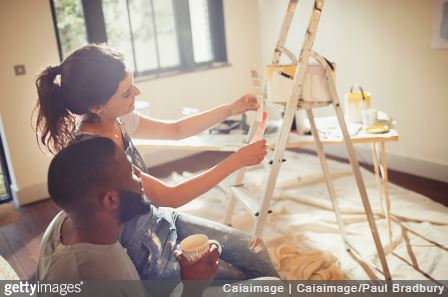 Couple en train de faire des travaux de rénovation dans une maison